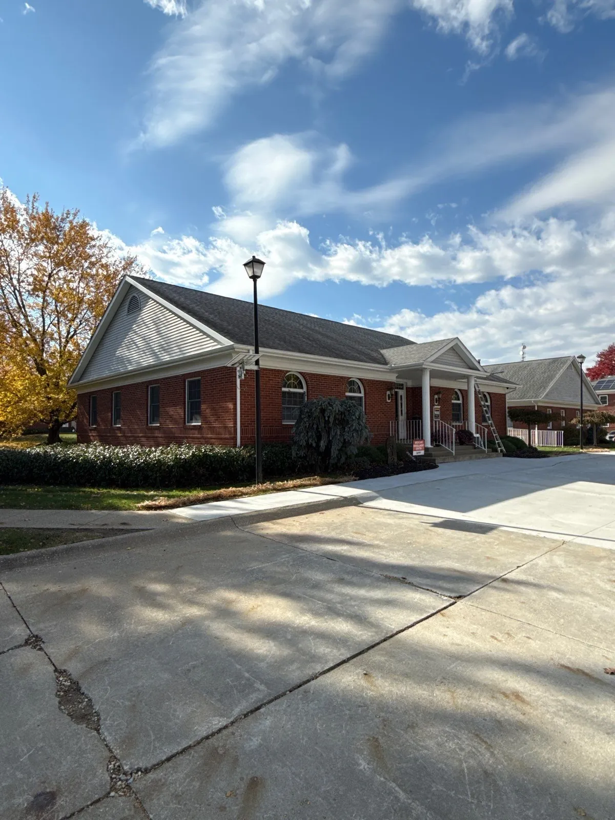 Single-story brick commercial office building with a new Owens Corning Williamsburg Gray shingle roof in Akron, Ohio
