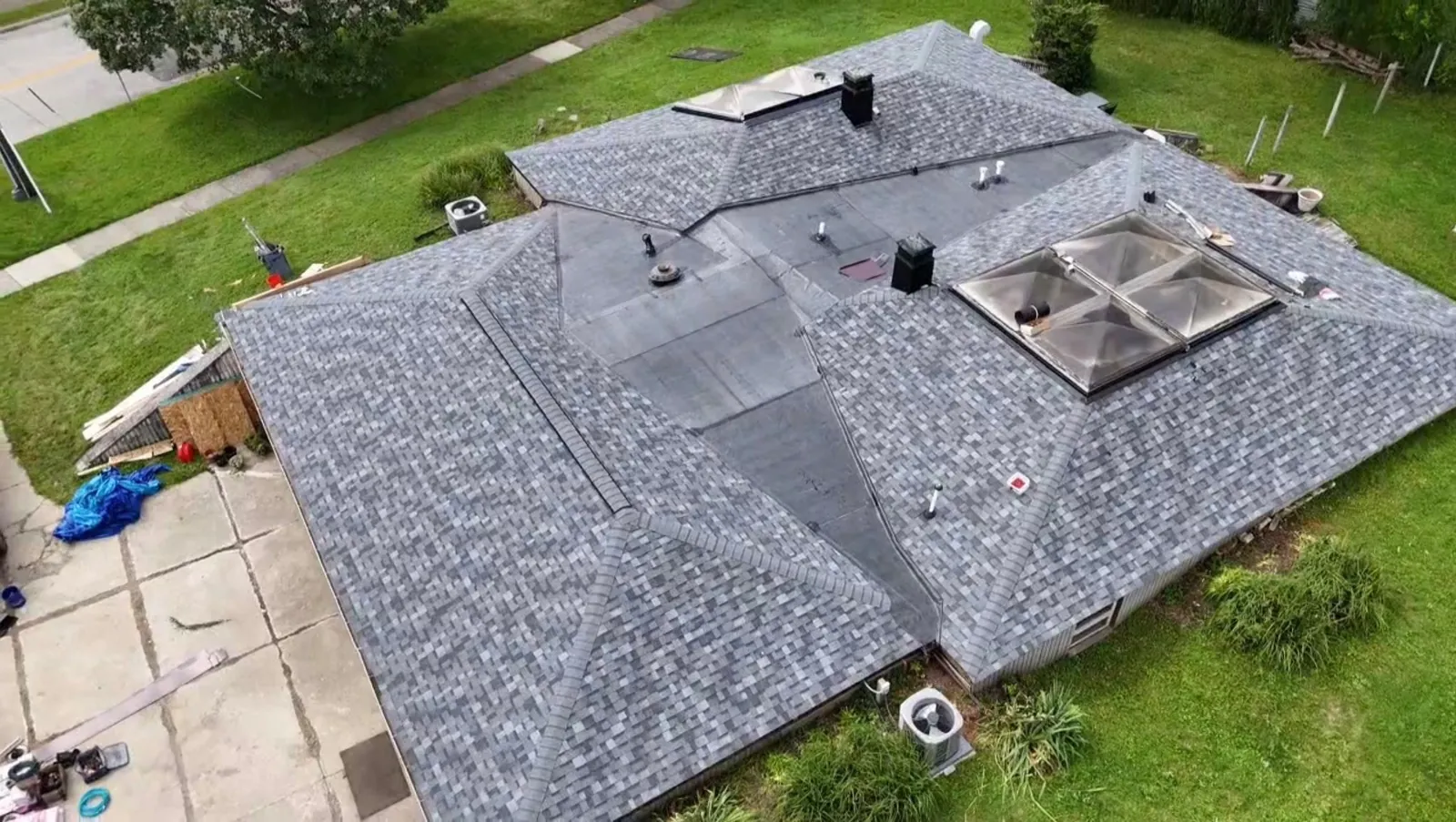 Aerial view of a home in Bedford, Ohio with Owens Corning Duration Slate Stone Grey shingles on the hip roof and EPDM on the flat sections around the skylights