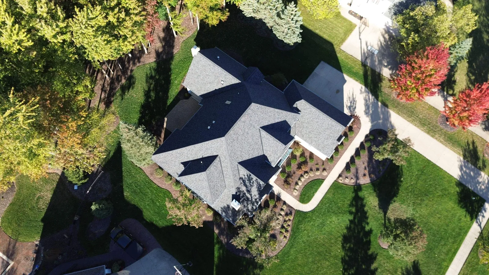 Overhead drone view of a large home with a new Owens Corning Duration Williamsburg Gray roof surrounded by trees in Brecksville, Ohio