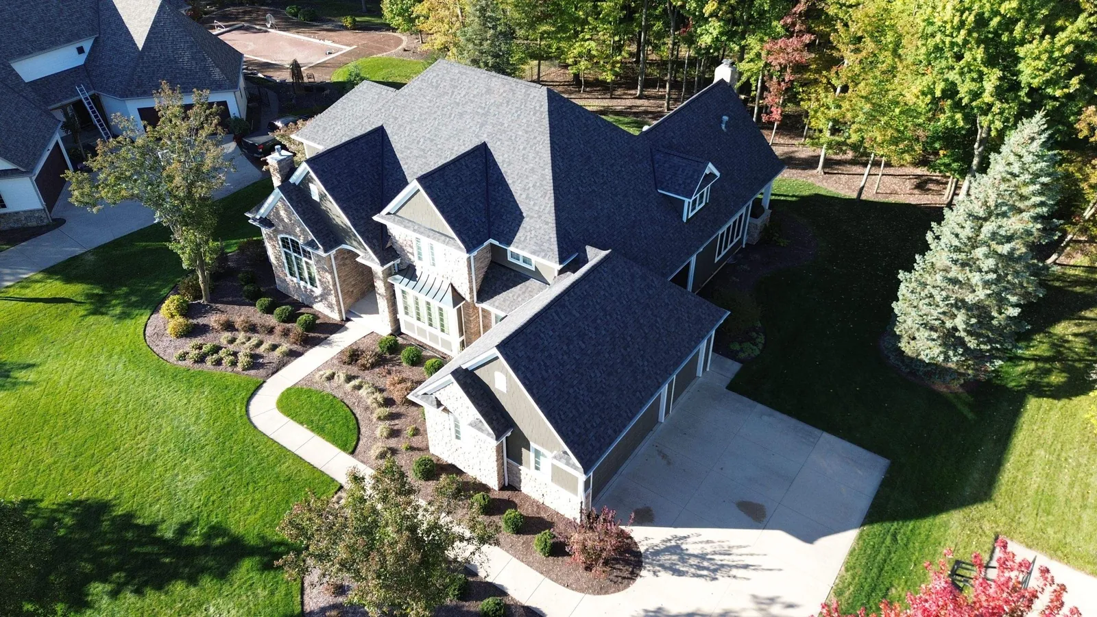 Drone photo of a multi-gable Brecksville, Ohio home showing the new Owens Corning Duration Williamsburg Gray shingles over the garage and dormers