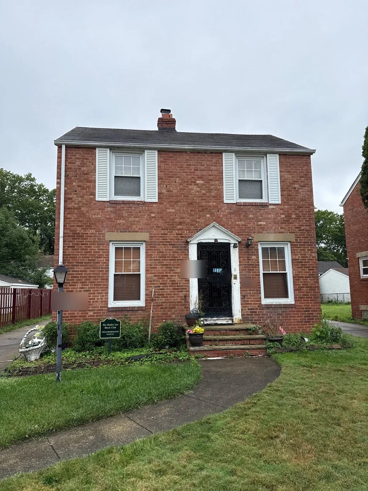 After: the same red brick colonial in Cleveland, Ohio with a new dark gray shingle roof