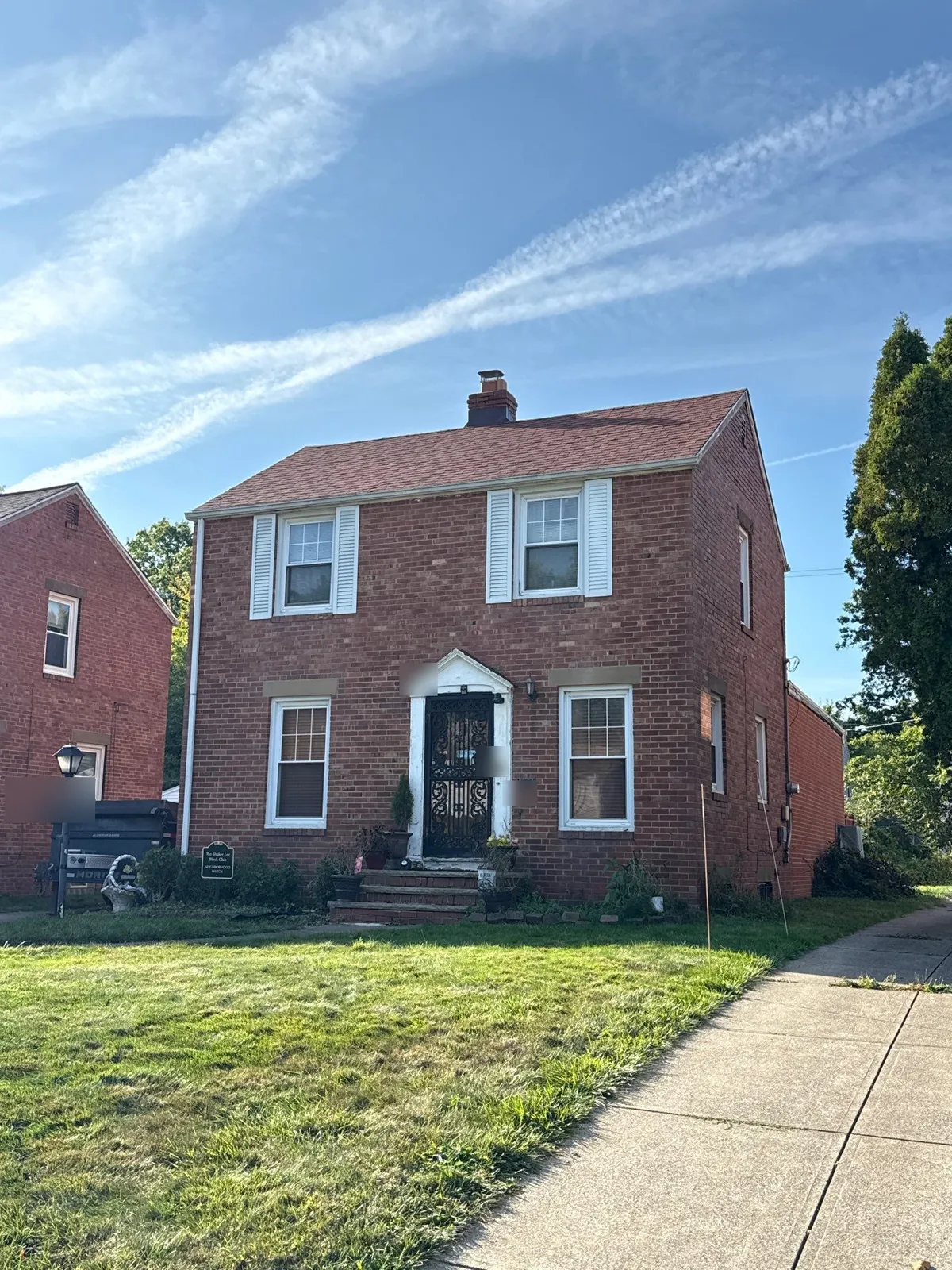 Before: red brick two-story colonial in Cleveland, Ohio with its old, faded red shingle roof