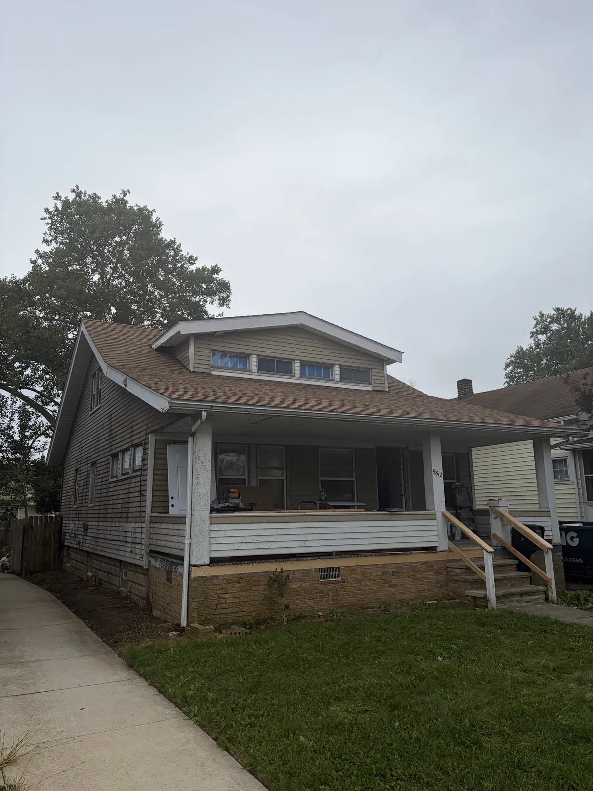 Bungalow with a wide covered front porch and a front dormer in Garfield Heights, Ohio, with a new Atlas ProLAM Desert Shake roof