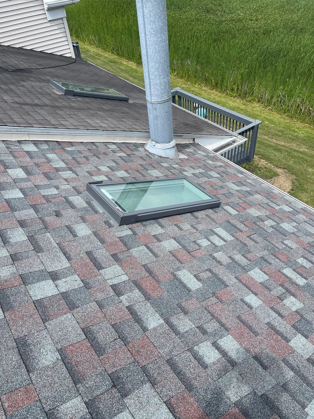 New shingle roof with a freshly installed skylight and vent pipe on a home in Medina, Ohio