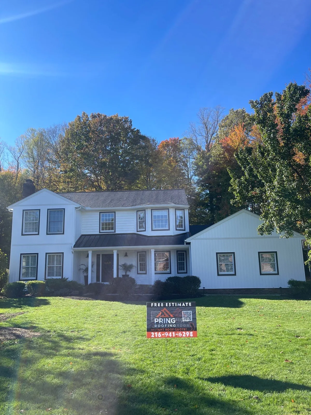 White two-story colonial with new siding and an Owens Corning shingle roof on a wide lawn in Munroe Falls, Ohio