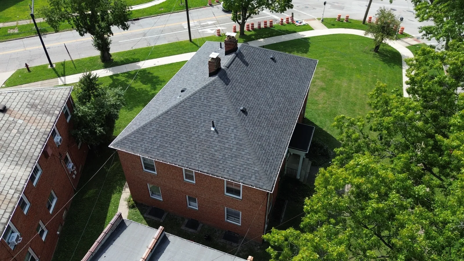 Aerial view of a red brick two-story home in University Heights, Ohio with a new Owens Corning Duration Williamsburg Gray roof that replaced the original slate